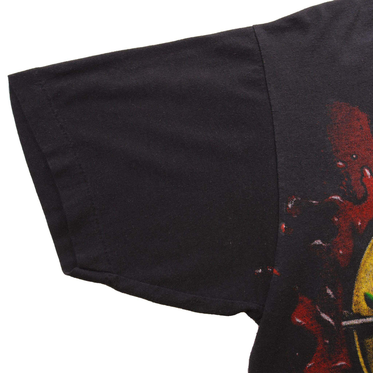 Close-up of black T-shirt sleeve, hem stitching, and edge of the back graphic