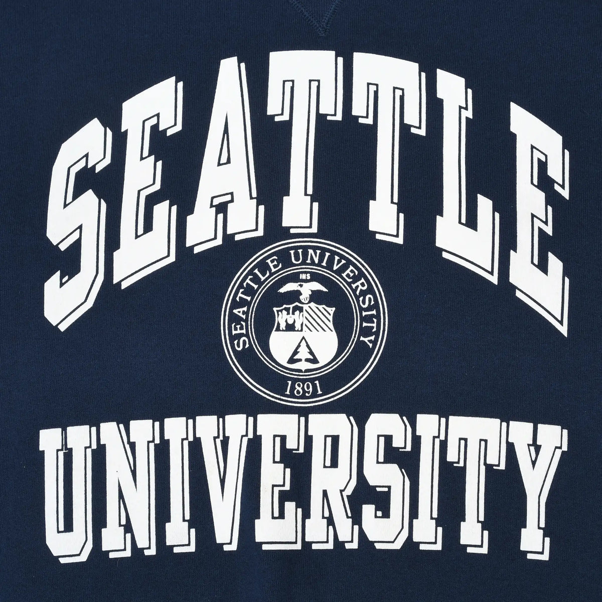 Close-up of white Seattle University lettering and circular crest on navy sweatshirt