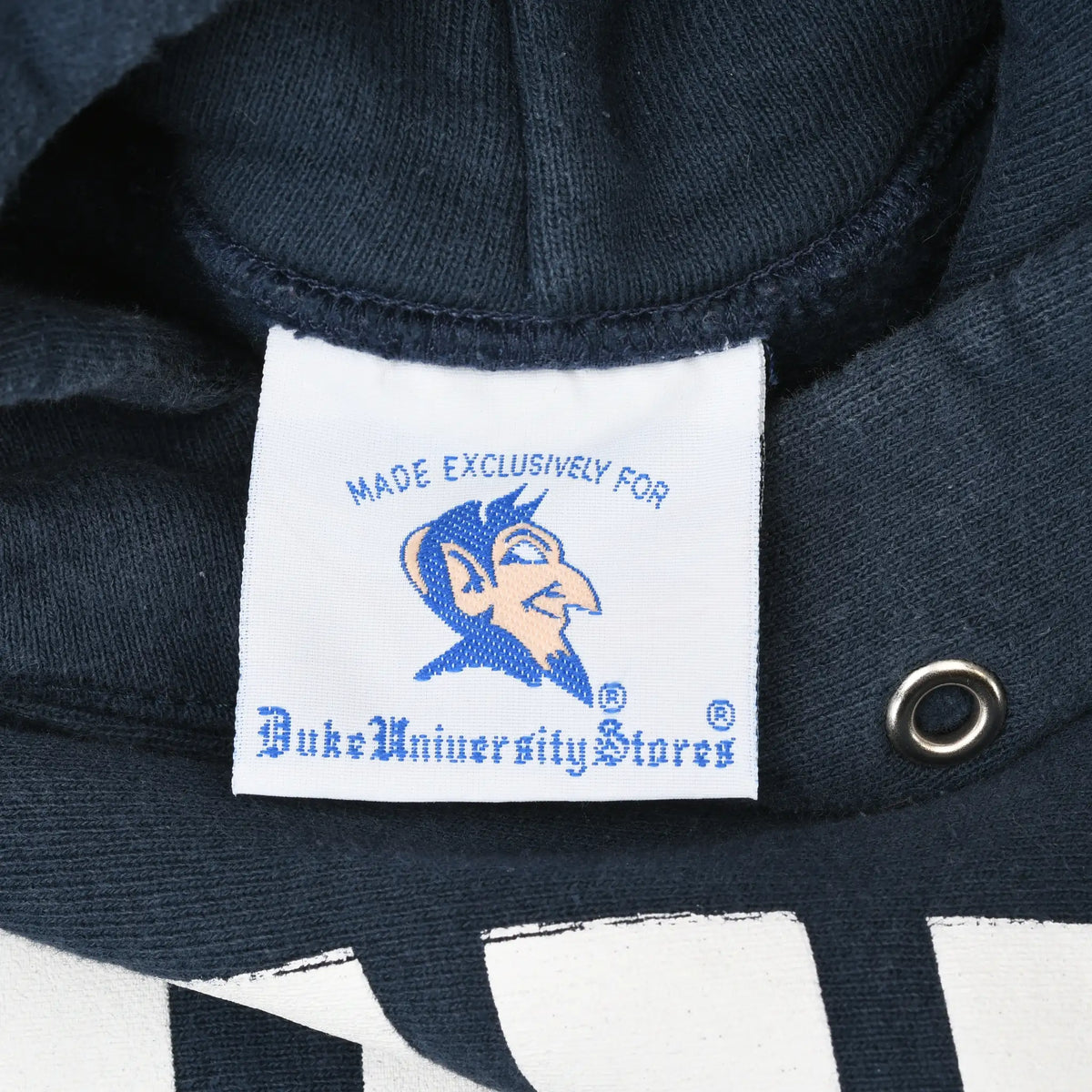 Close-up of Duke University Stores neck label with Blue Devil graphic inside navy hoodie