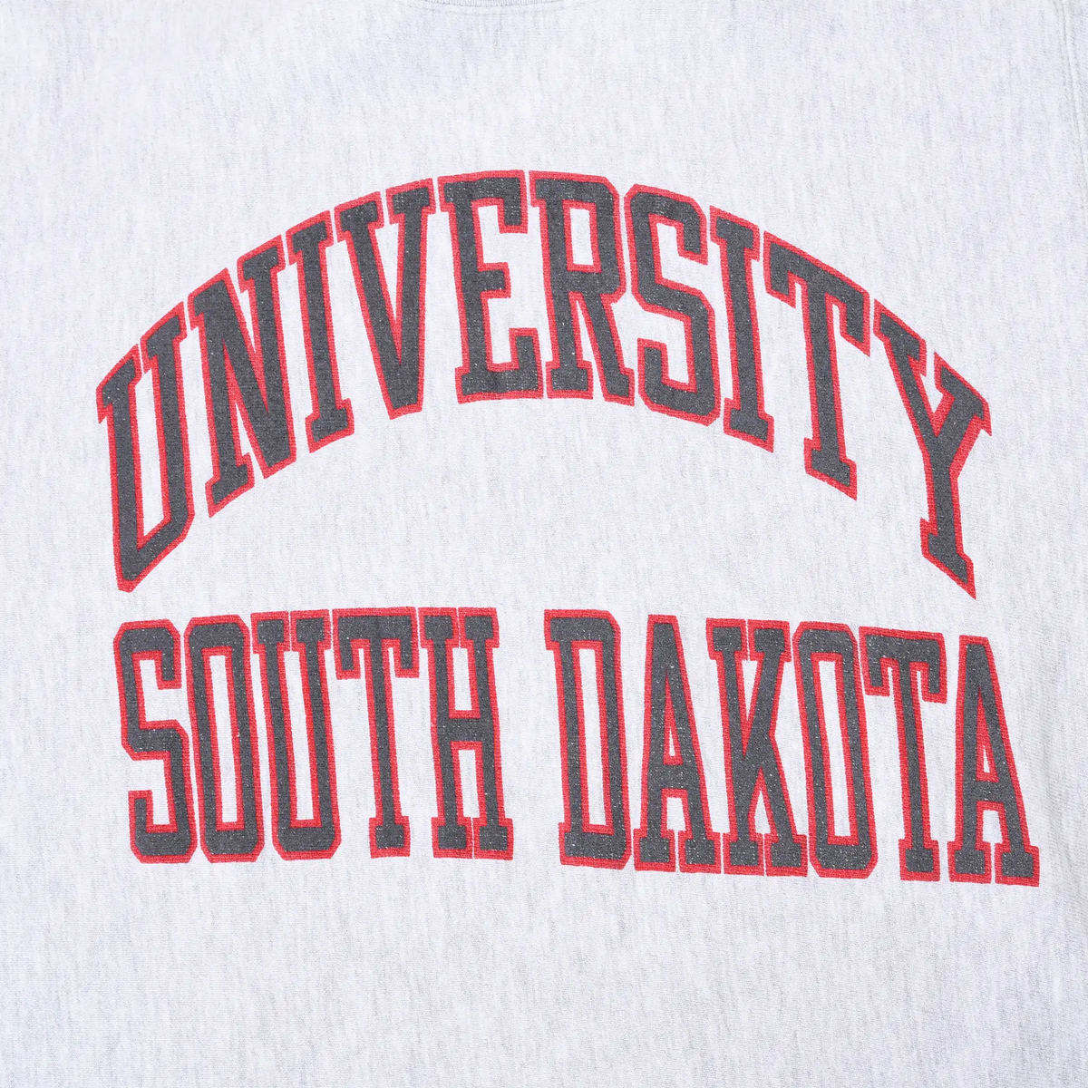 Close-up of red and black University South Dakota chest print on gray fabric