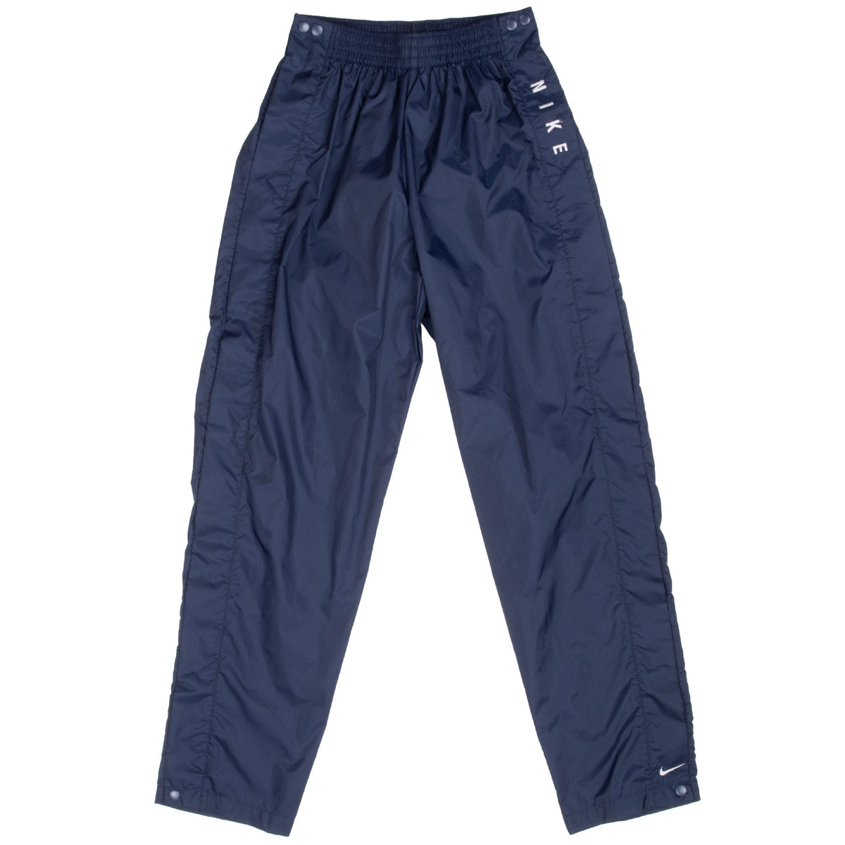 Front of navy blue Nike track pants with white leg logos and side snap buttons