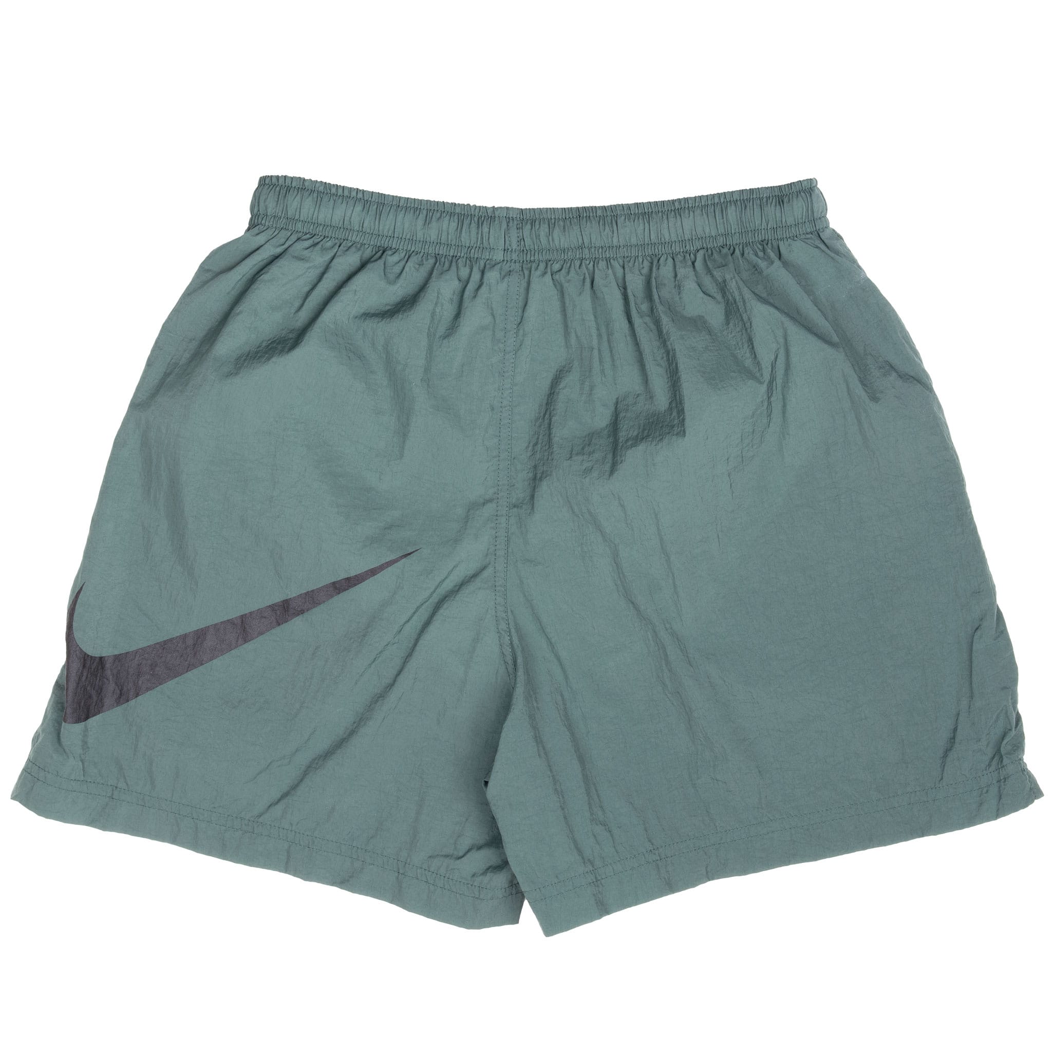 Back of green Nike youth swim trunks with large black Swoosh graphic