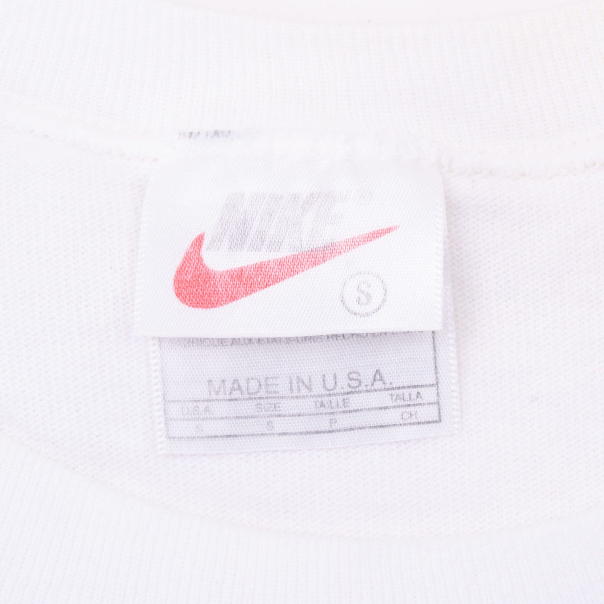 Nike neck tag showing red Swoosh, size small and Made in USA text