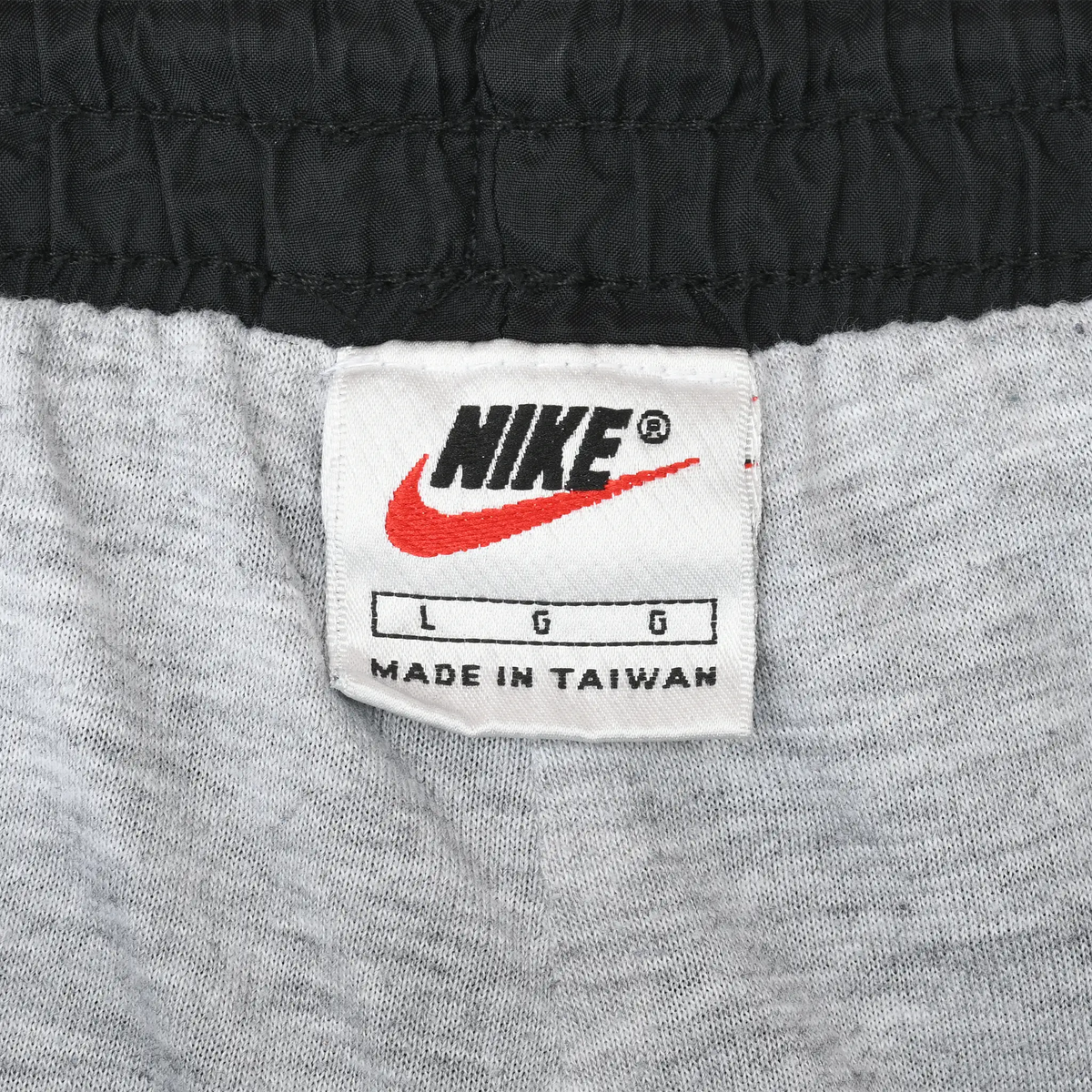 Close-up of Nike size L waistband label with red Swoosh