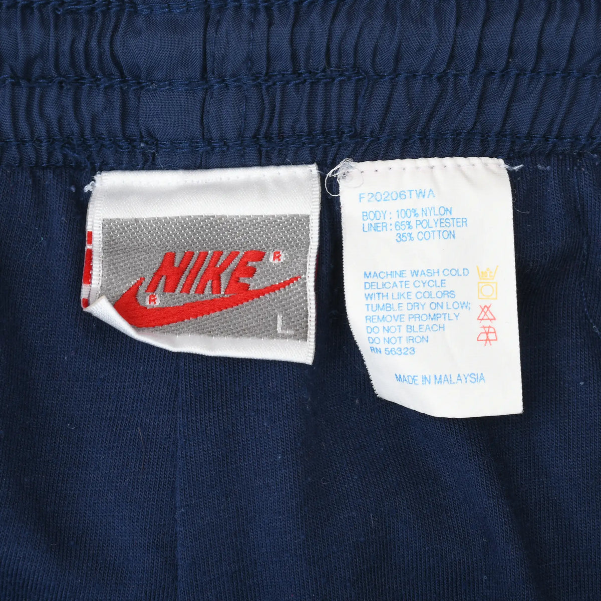 Nike size L brand and care labels inside navy blue track pants