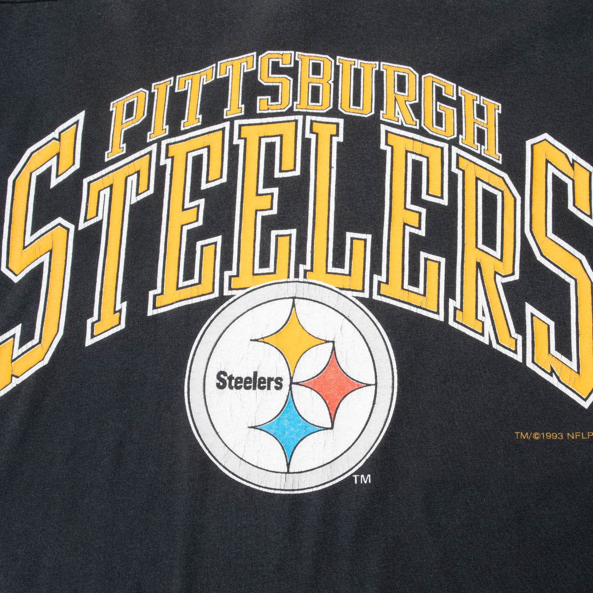 Close-up of gold Pittsburgh Steelers lettering and team logo on black fabric