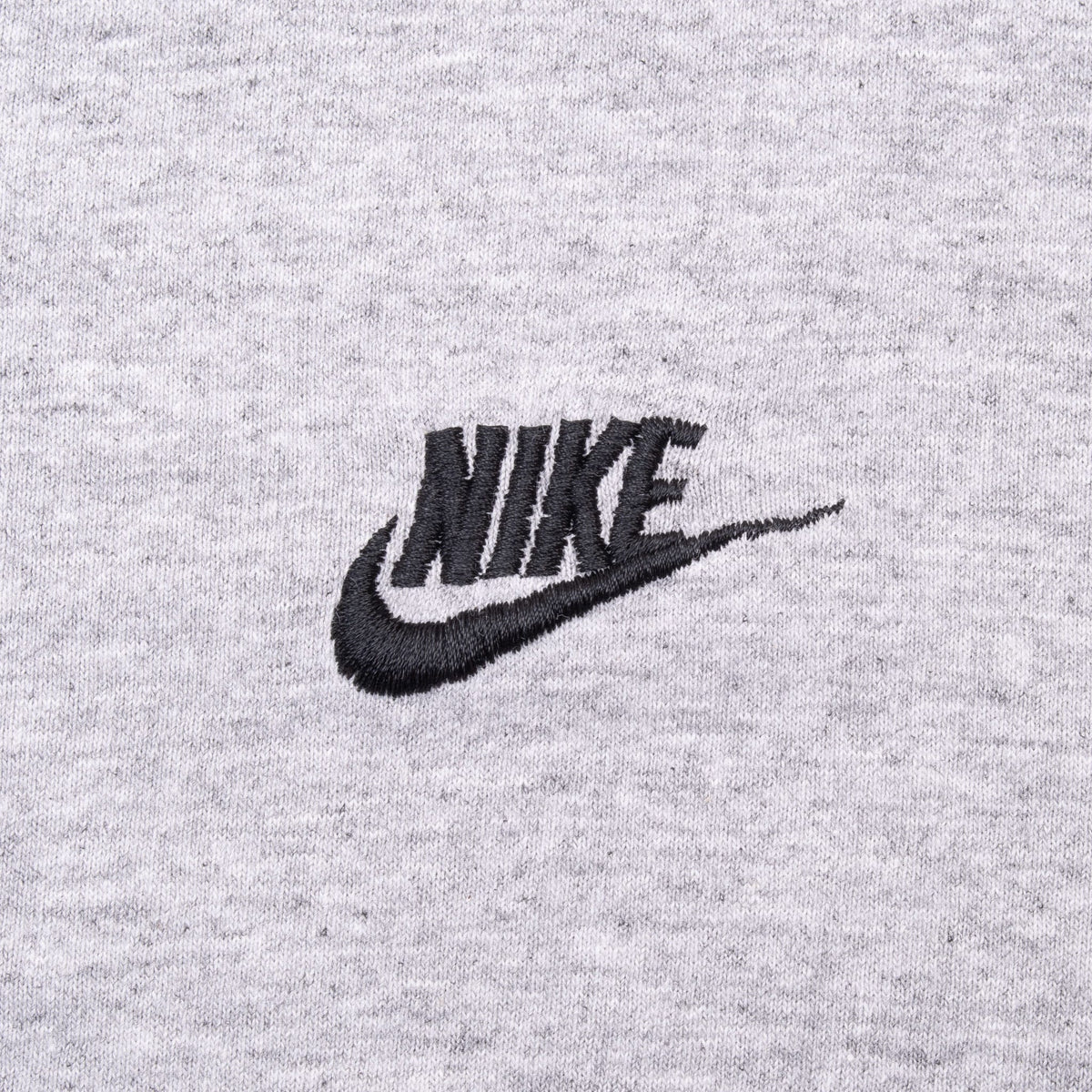 Close-up of black embroidered Nike wordmark and Swoosh on heather grey fabric