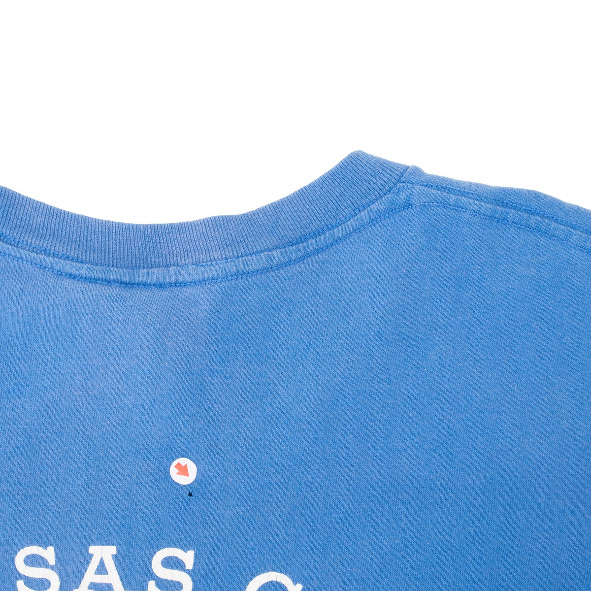 Back collar detail of blue T-shirt with a small marked spot below the neckline