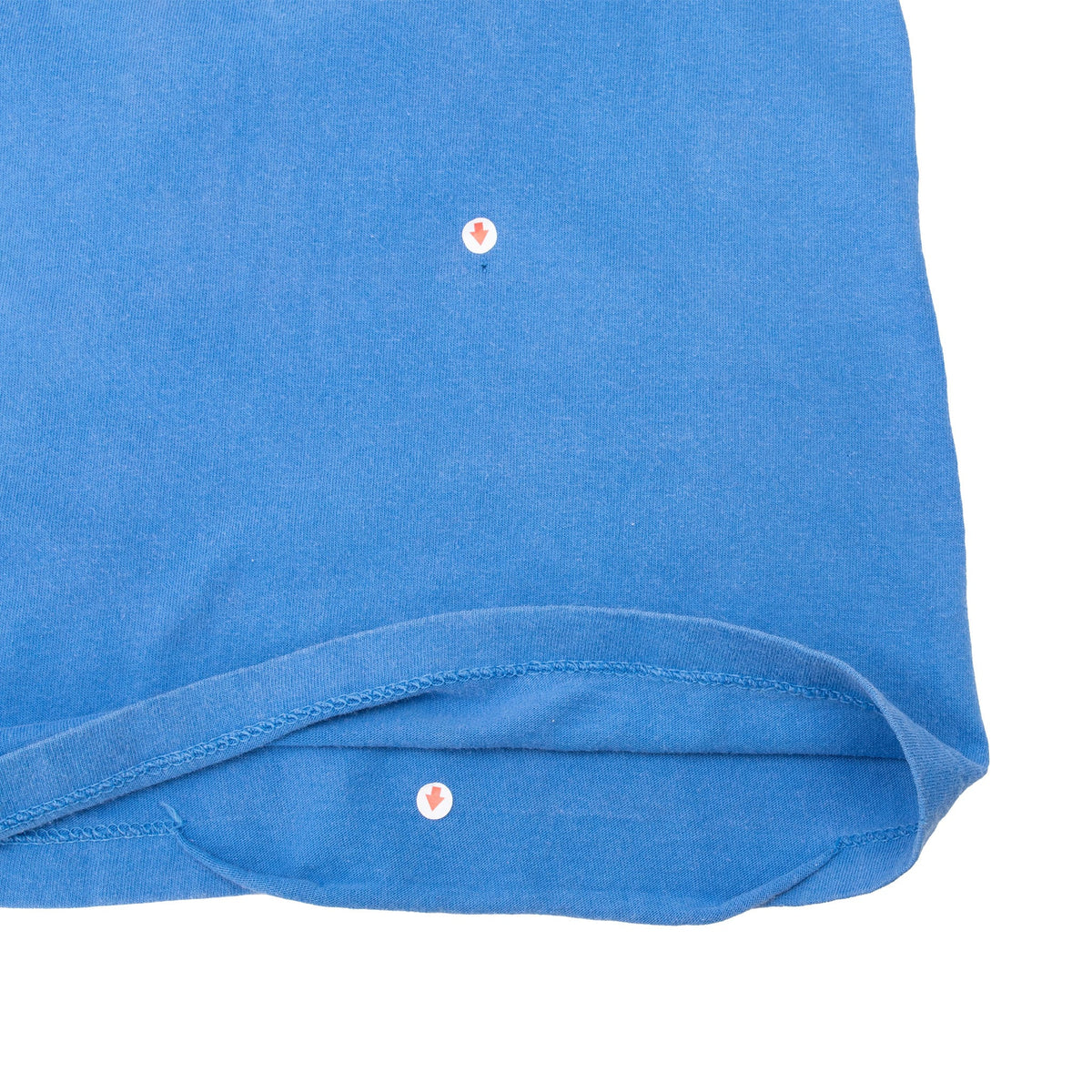 Blue T-shirt hem detail with two small marked spots