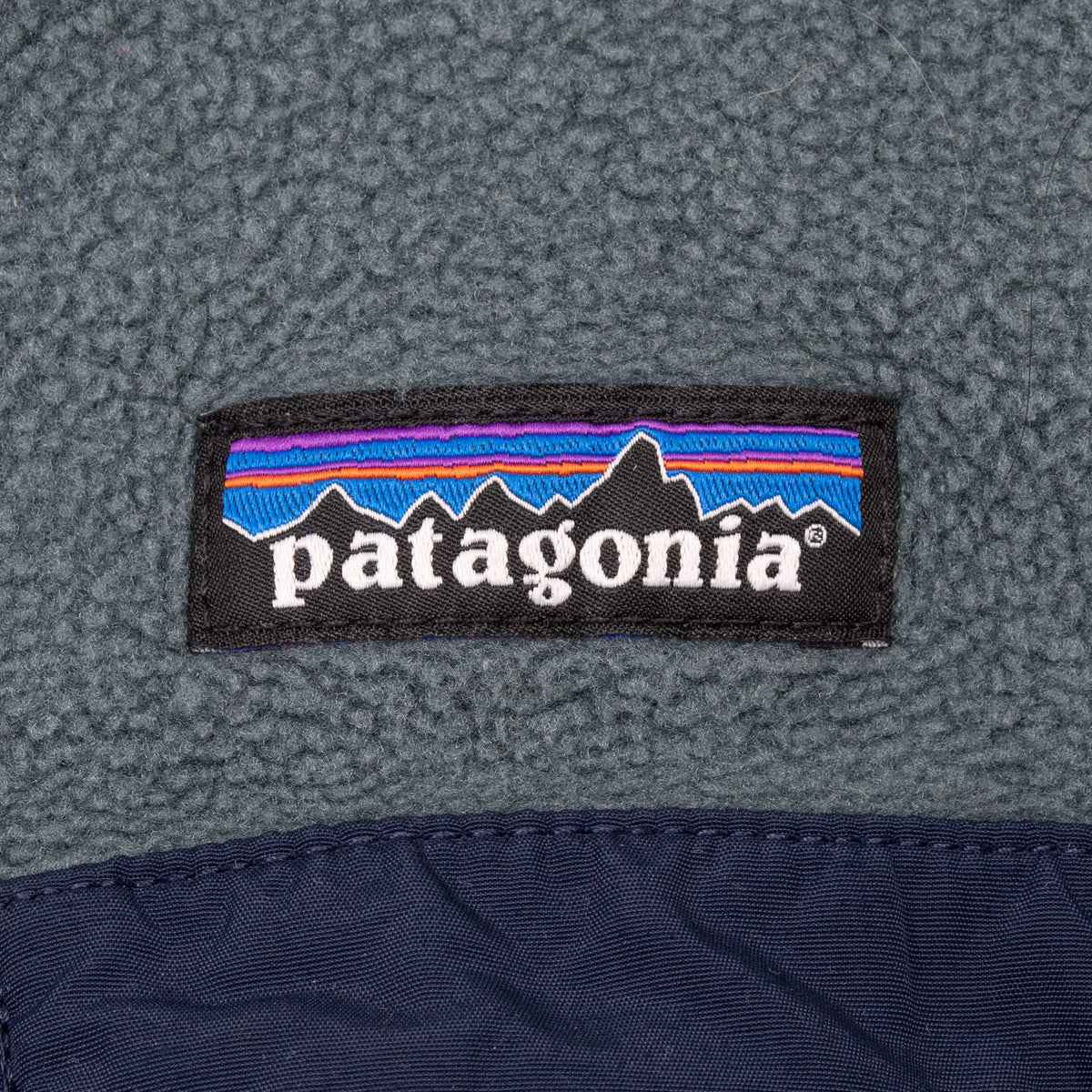 Close-up of Patagonia chest logo above the navy-trimmed pocket