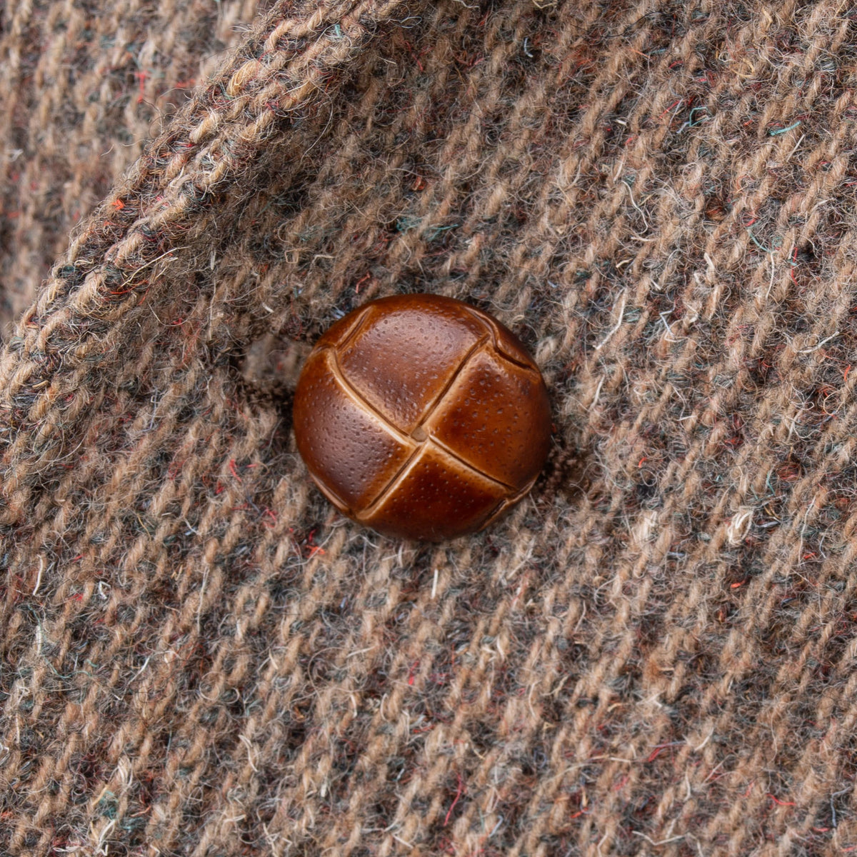 Close-up of patterned brown button on textured Pendleton wool blazer