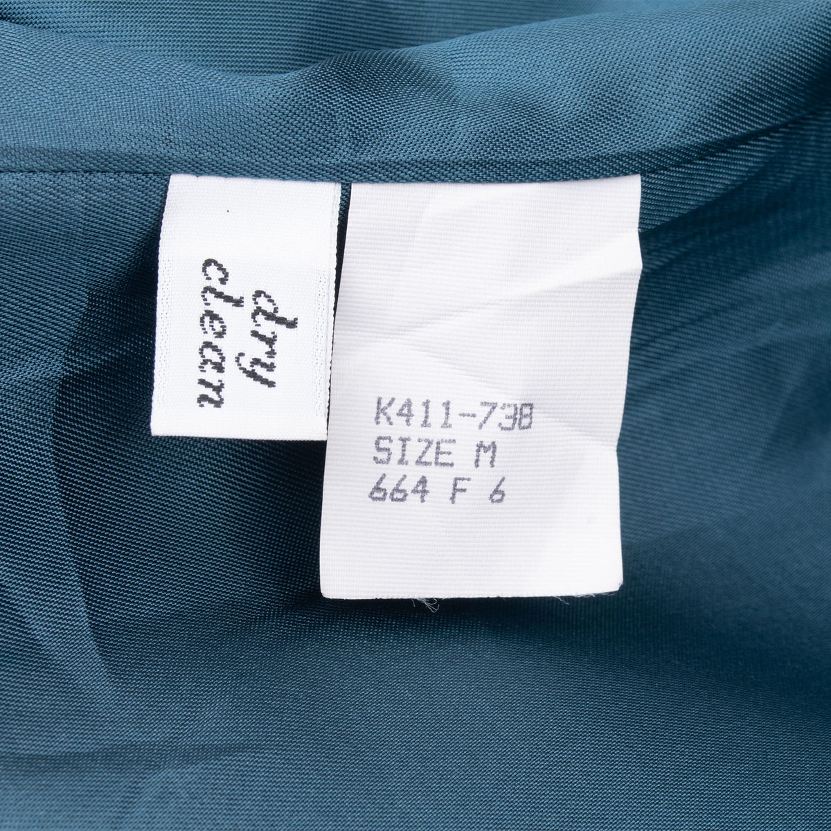 Dry clean and size M care labels inside blue blazer lining