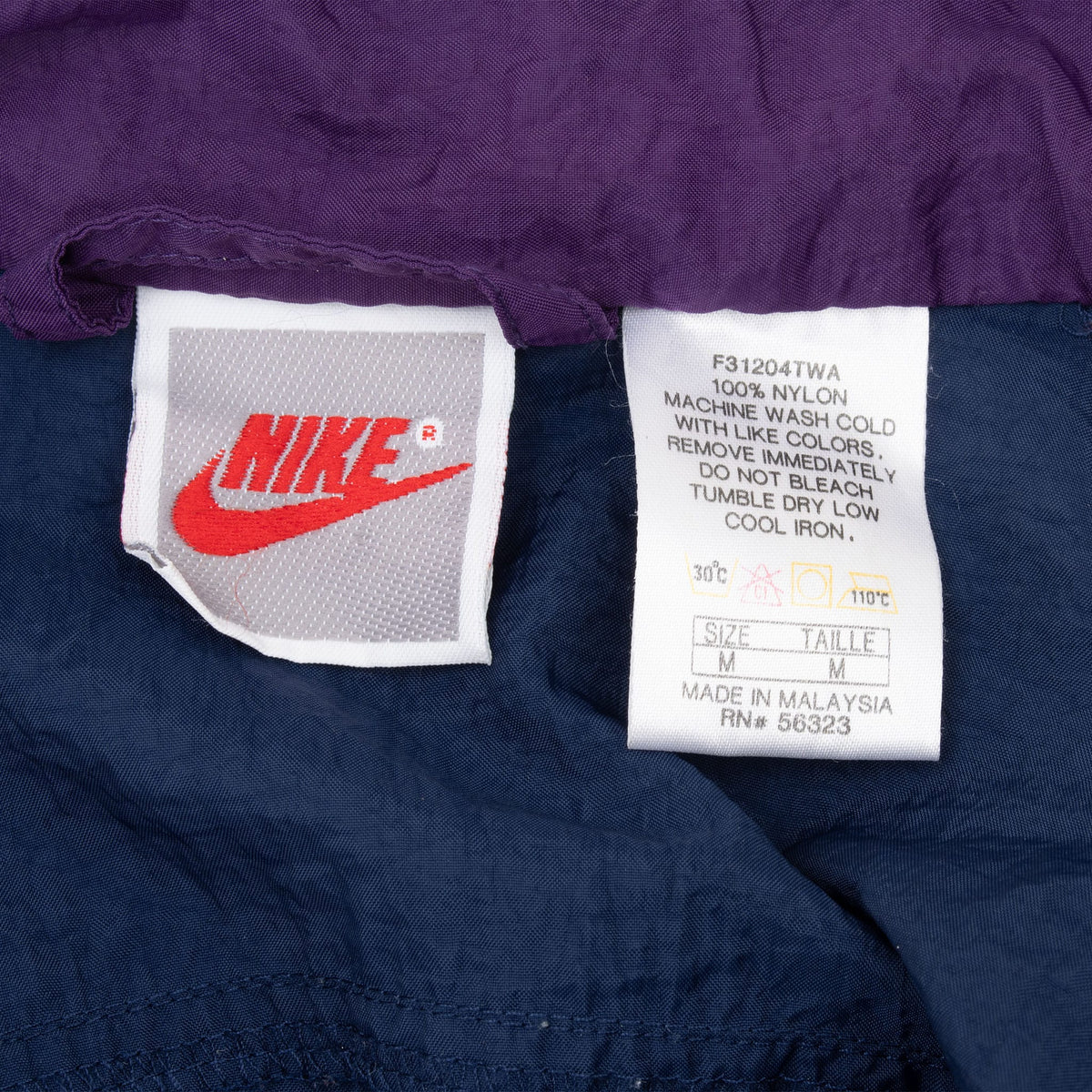 Nike neck and care labels showing size medium and 100% nylon