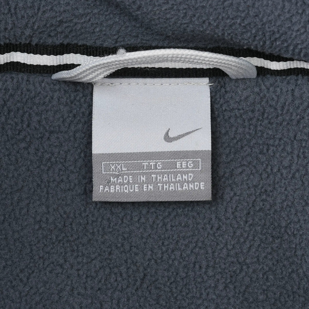 Nike XXL garment label against gray fleece lining inside the jacket