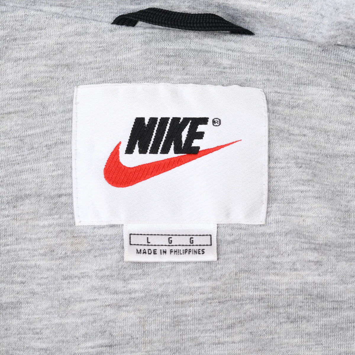 Nike neck label with black logo, red Swoosh, and Large size marking on gray lining