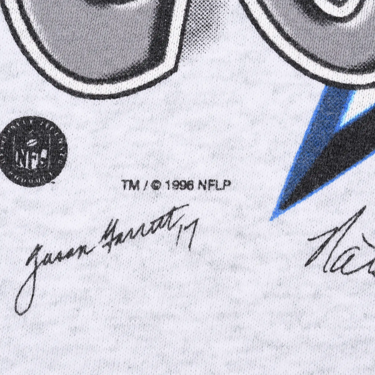 Close-up of NFL logo, 1996 NFLP copyright text, and printed signatures on grey fabric