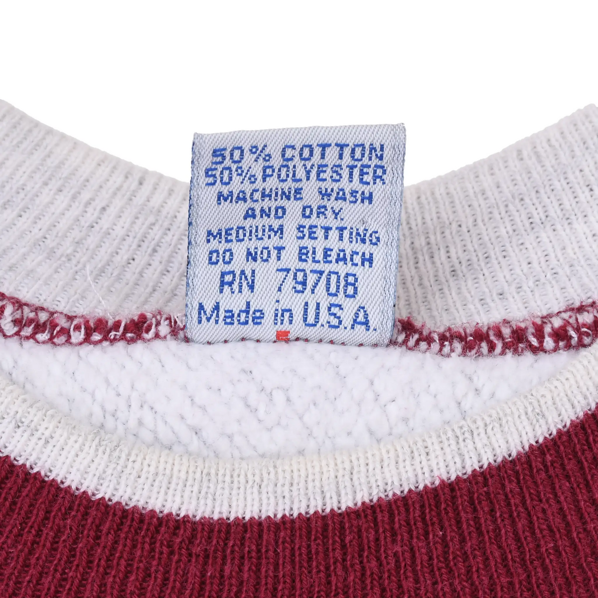 Close-up of sweatshirt care label listing cotton blend, washing instructions, and Made in USA