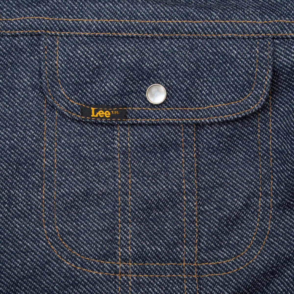 Close-up of Lee jacket chest pocket with pearl snap and orange stitching