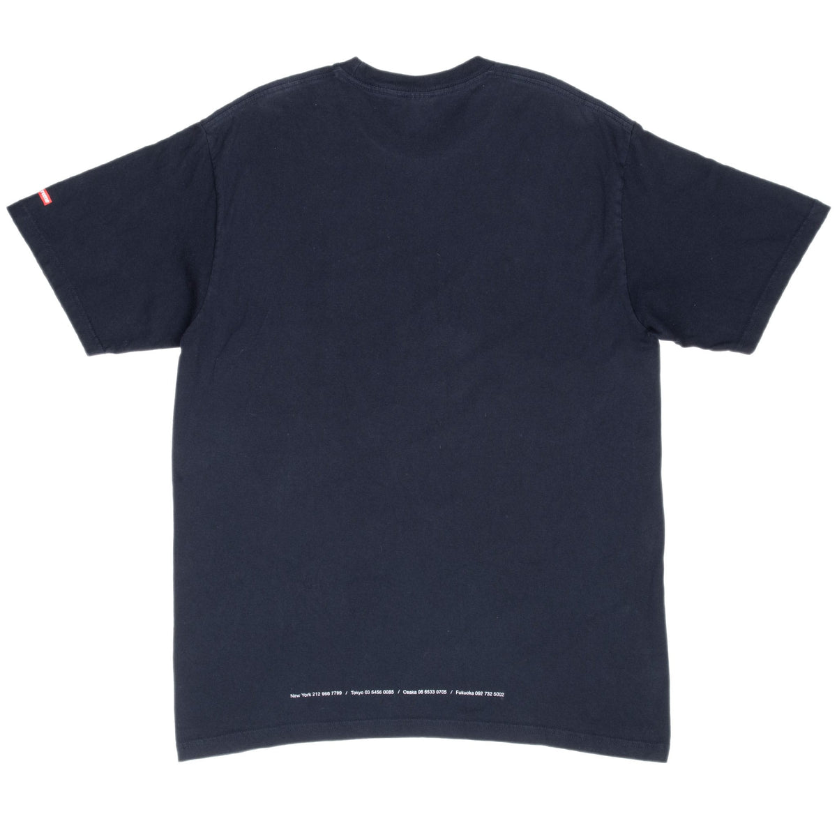 Back of black Supreme T-shirt with small white text near the lower hem