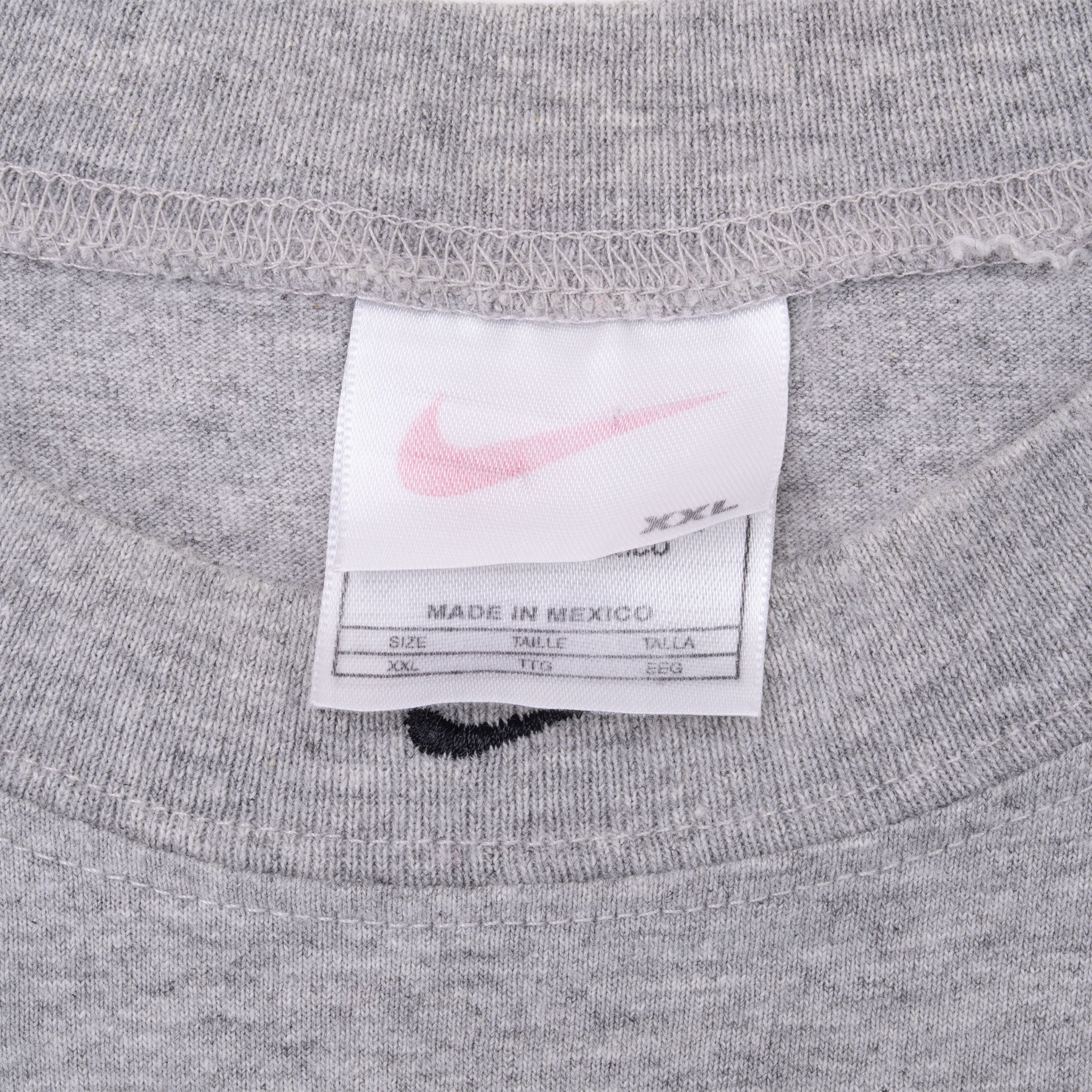 Close-up of Nike neck and care labels inside grey sleeveless shirt