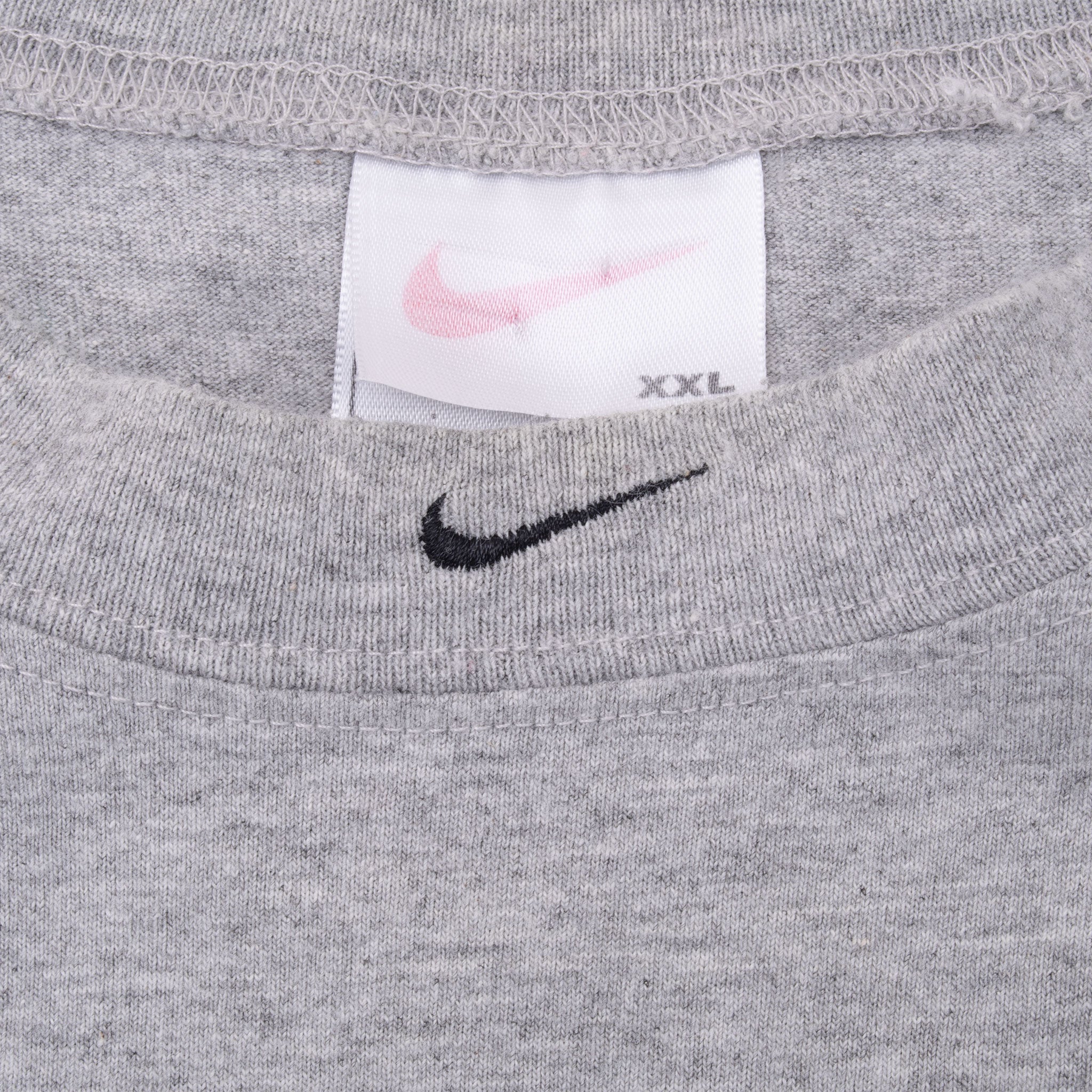 Close-up of Nike neck tag and black Swoosh embroidery on grey sleeveless shirt