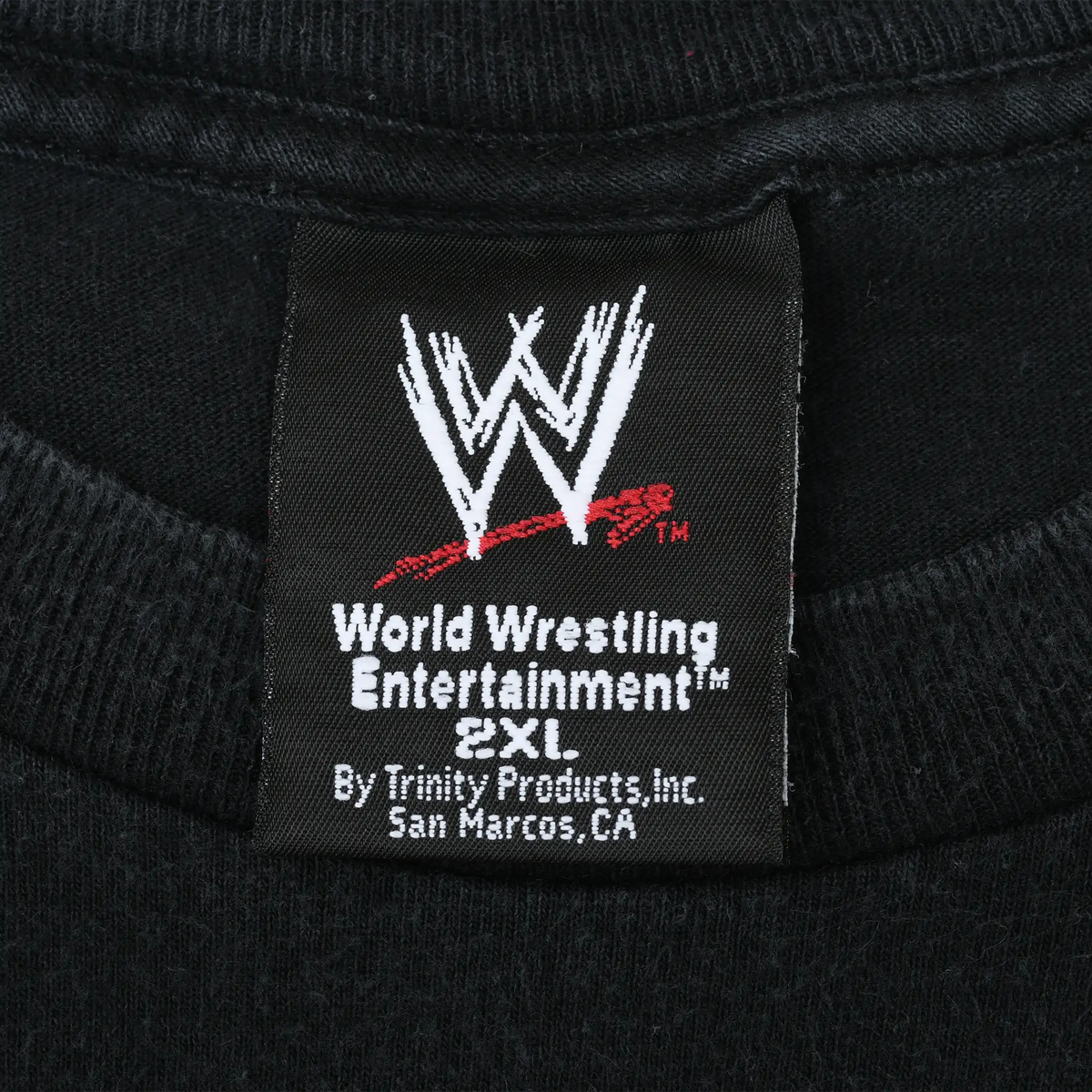 Close-up of WWE neck tag marked World Wrestling Entertainment and 2XL