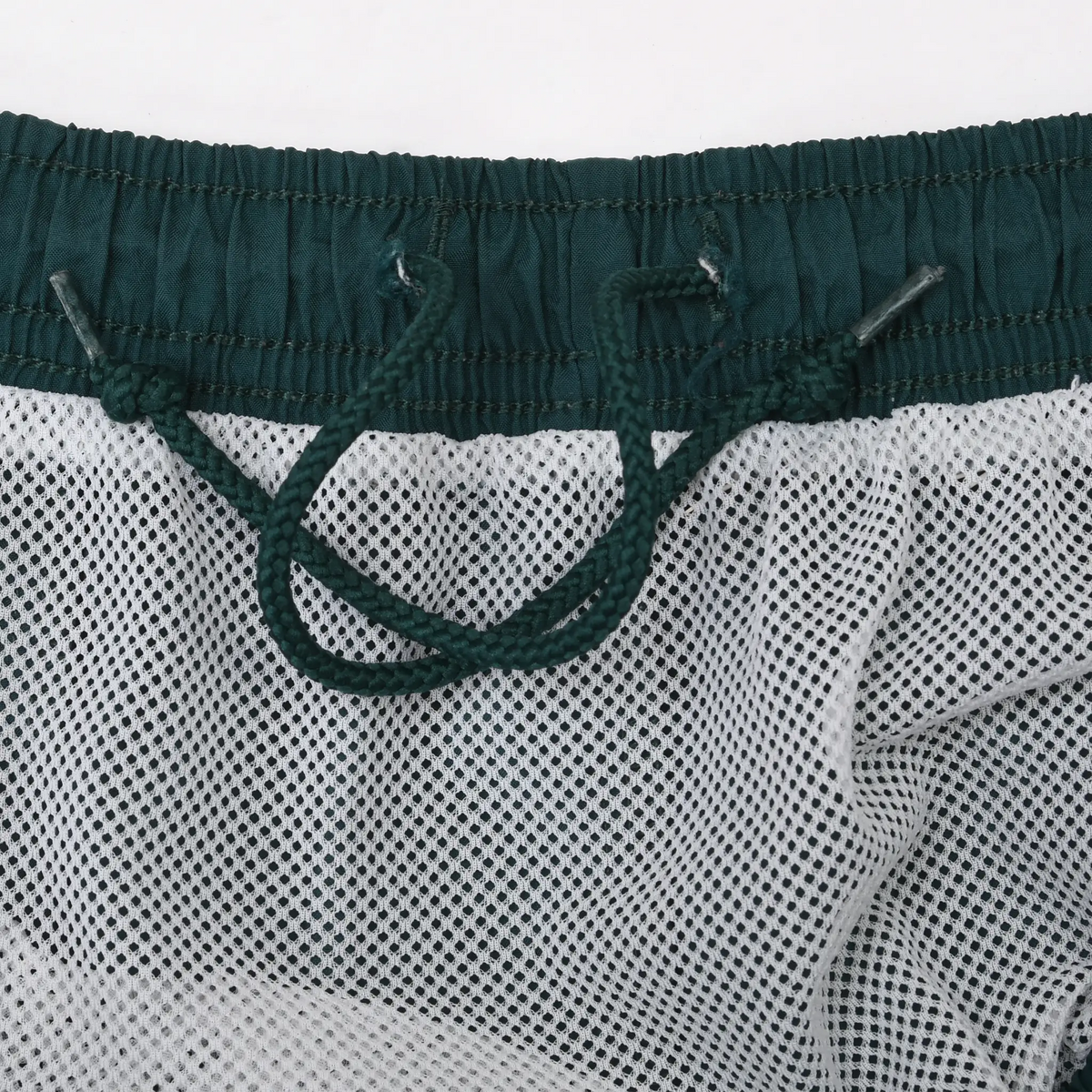 Interior waistband detail with green drawstring and white mesh brief lining