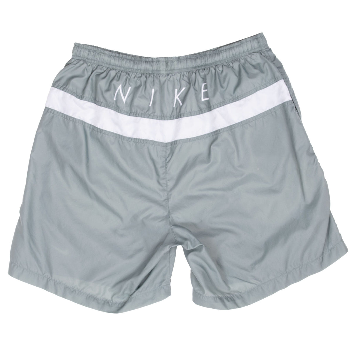 Back of green Nike swimming trunks with embroidered lettering and curved white accent panel