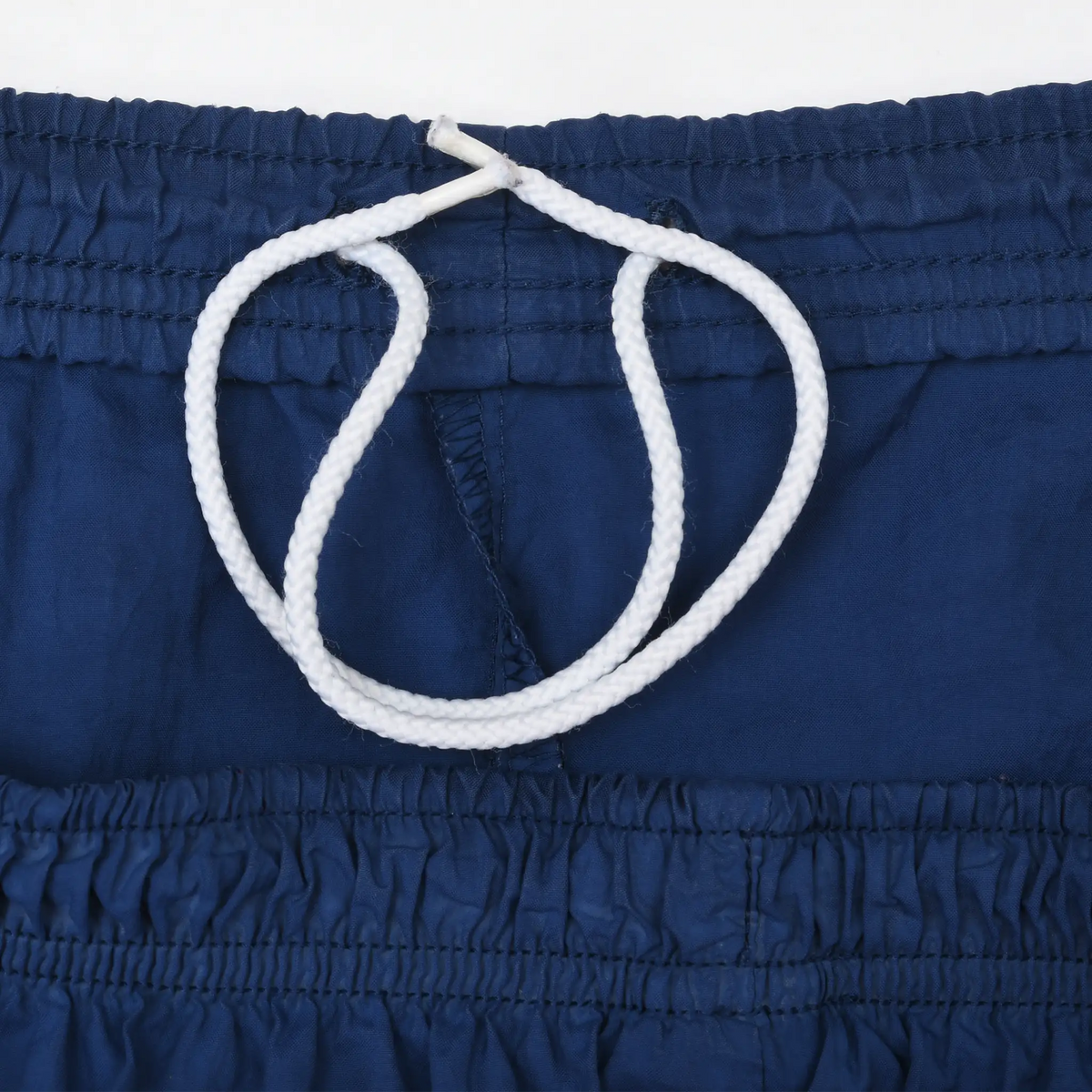 Close-up of white drawstring inside the navy blue elastic waistband