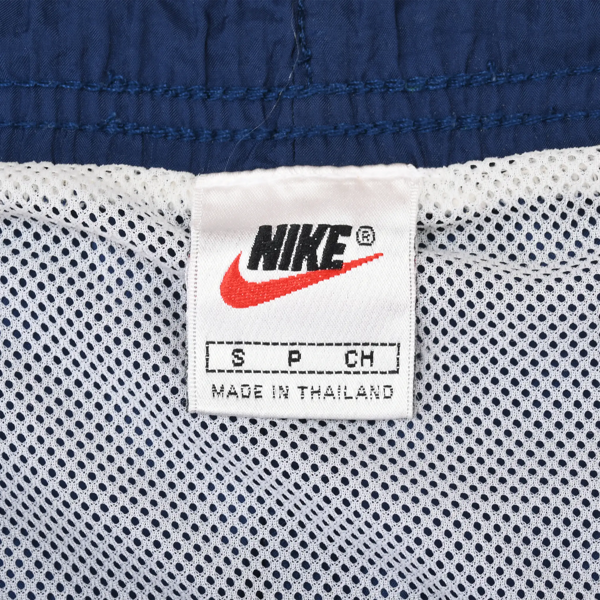 Nike label detail inside navy swim trunks with white mesh lining