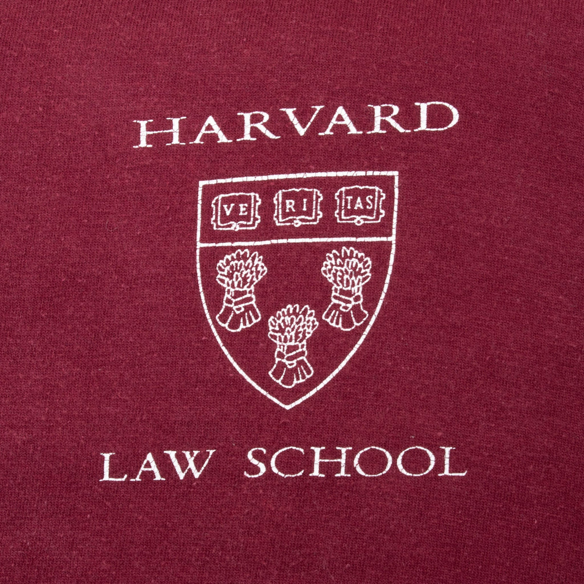 Close-up of white Harvard Law School crest print on burgundy fabric