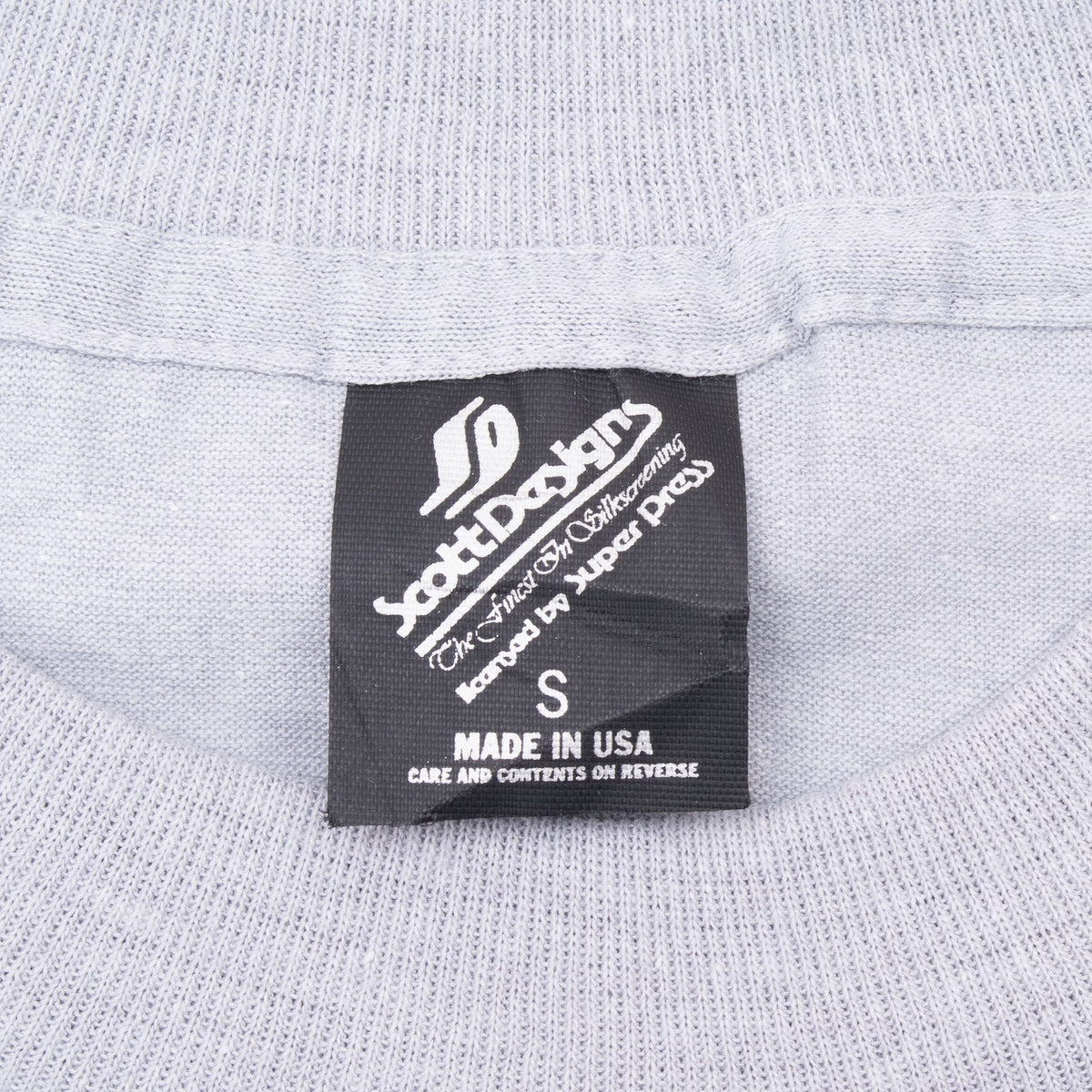 Black neck tag marked size S and Made in USA on gray T-shirt