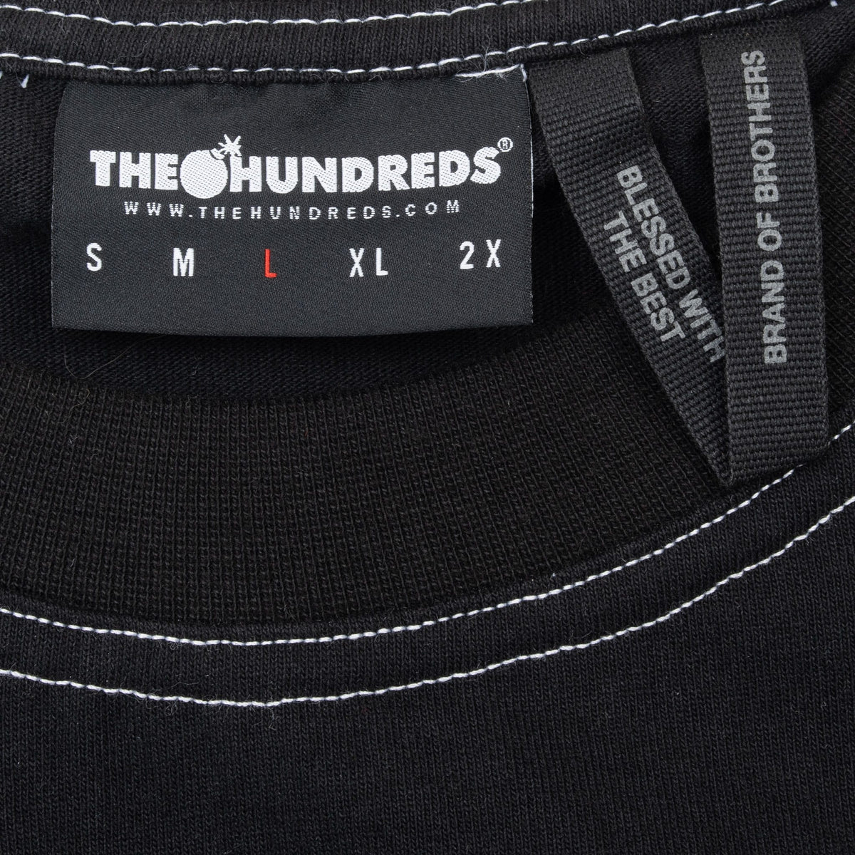 The Hundreds neck label marked size large inside black T-shirt with white contrast stitching
