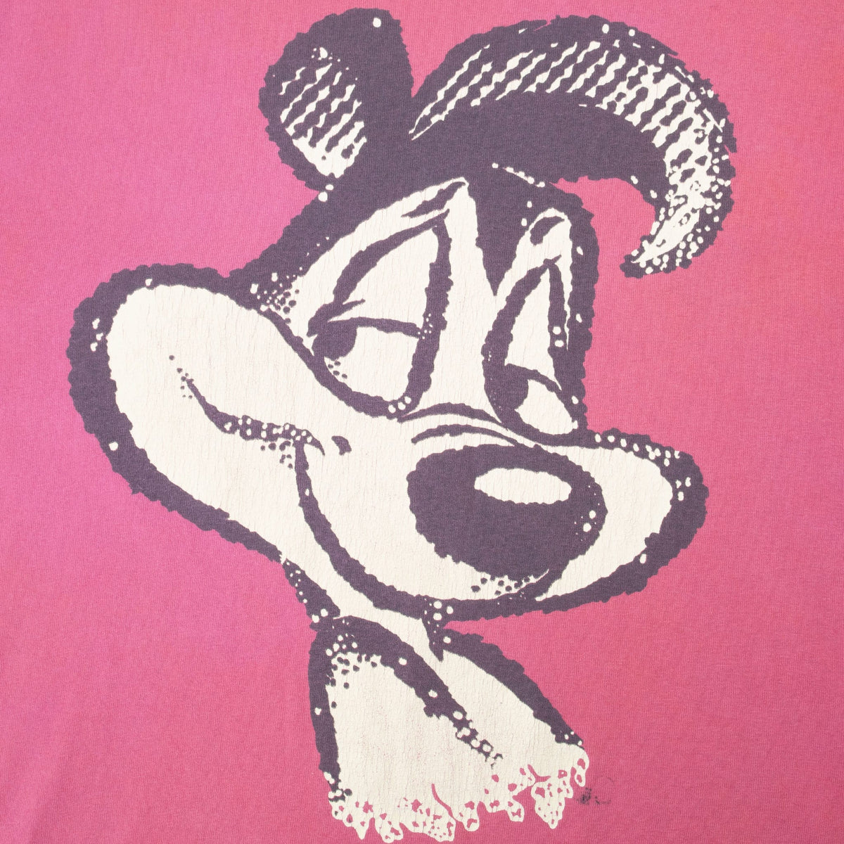 Close-up of distressed Pepe Le Pew portrait print on pink fabric
