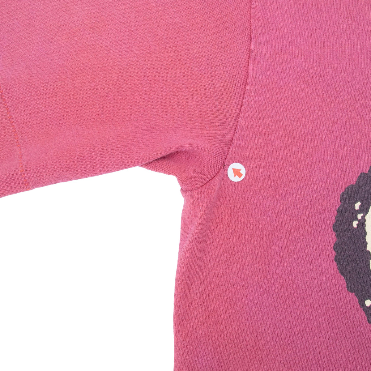 Close-up of sleeve and underarm seam detail on pink T-shirt