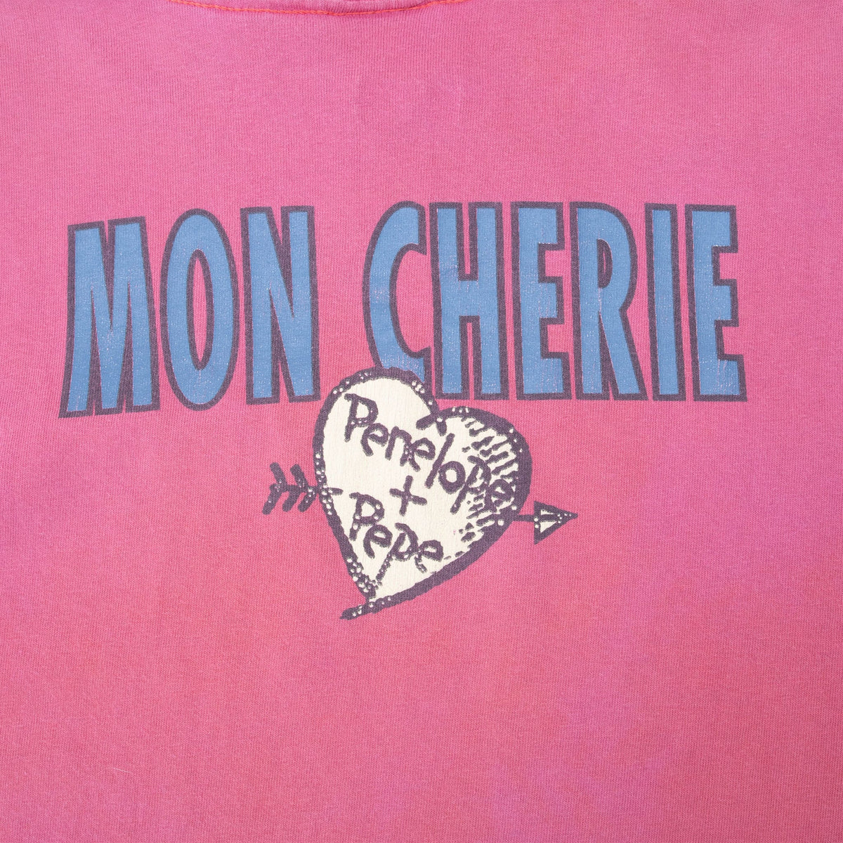 Close-up of back Mon Cherie print above arrow-pierced Penelope + Pepe heart