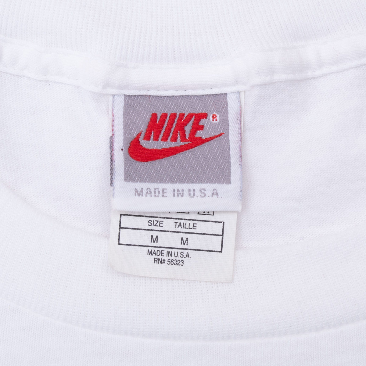 Nike neck tag showing red logo, size medium and Made in USA text