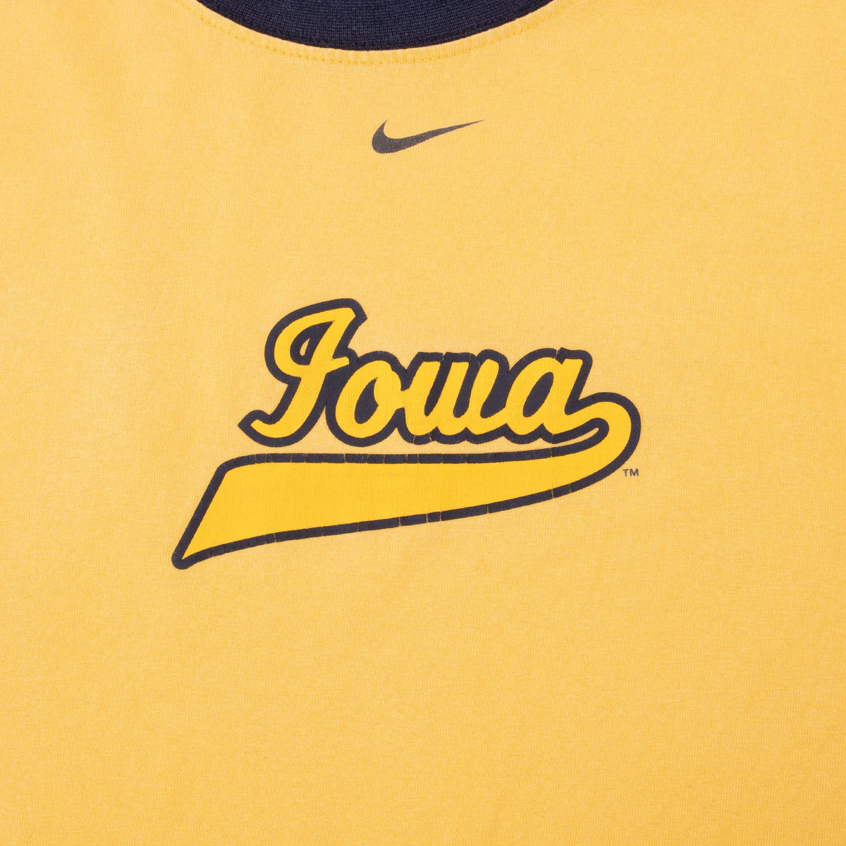 Close-up of black Nike Swoosh and Iowa script chest print on yellow T-shirt