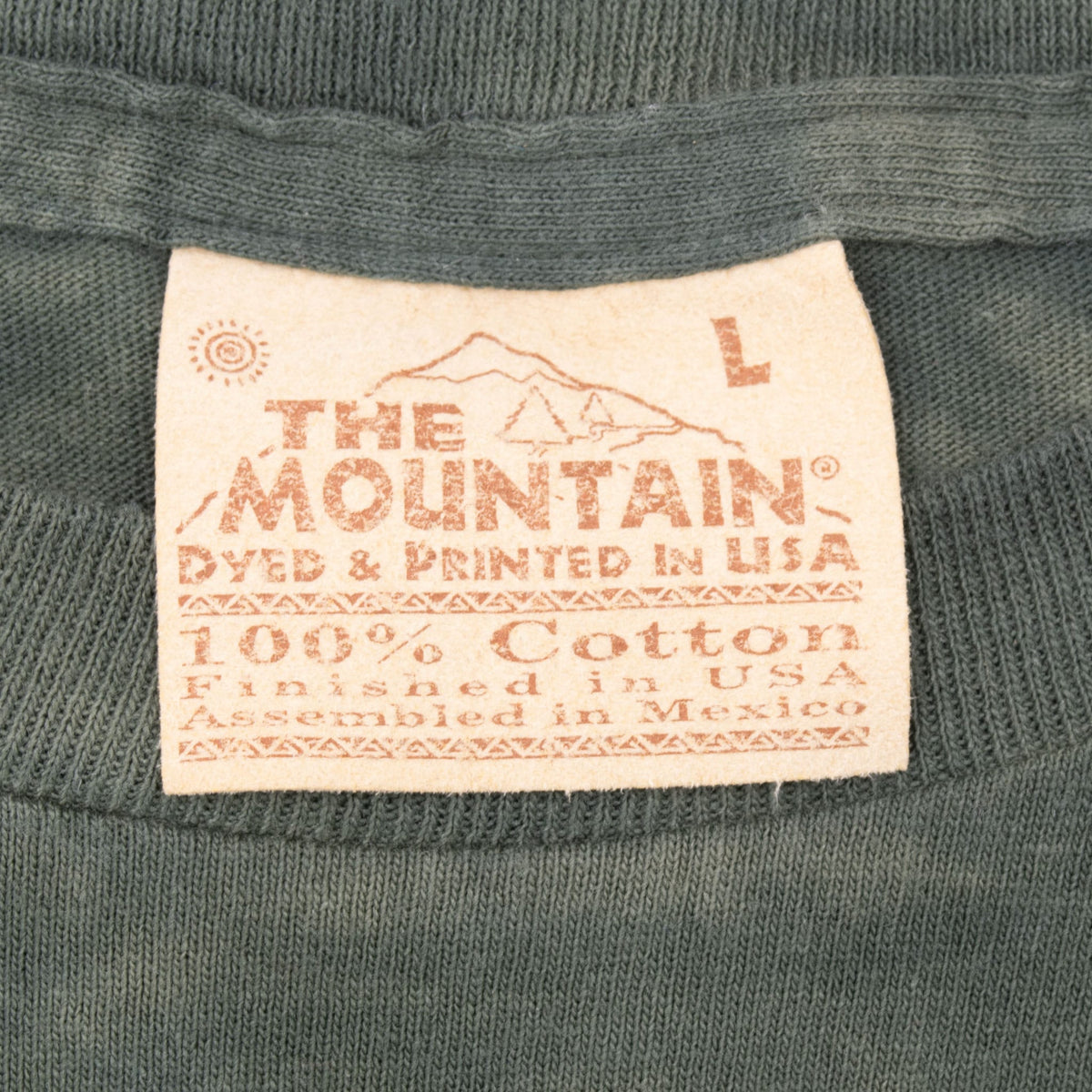The Mountain size Large neck tag on dark green T-shirt