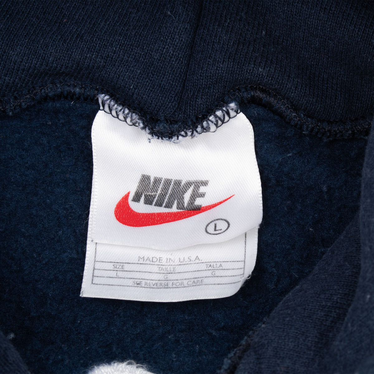 Nike neck tag showing size Large and Made in USA on navy blue hoodie