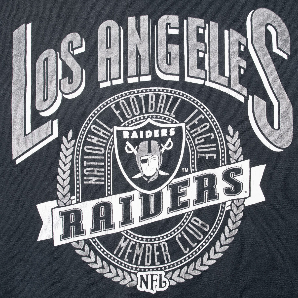 Close-up of silver-and-white Los Angeles Raiders shield and NFL front print