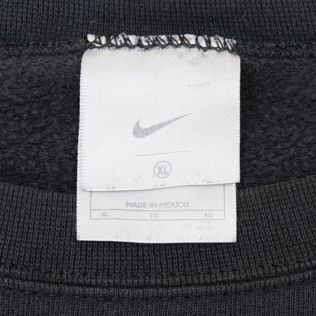 Close-up of Nike XL neck label inside black sweatshirt