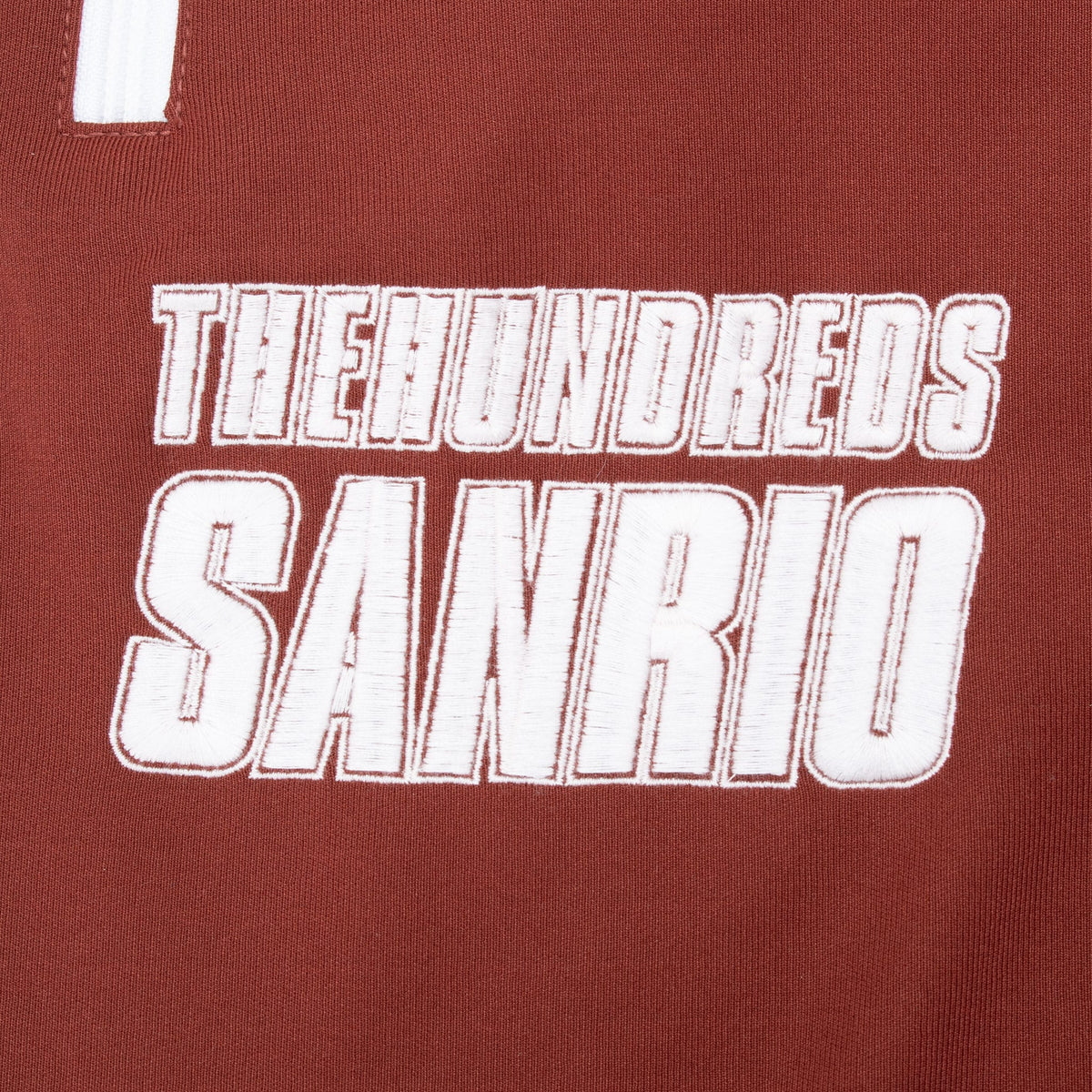 White embroidered The Hundreds Sanrio lettering on burgundy fabric