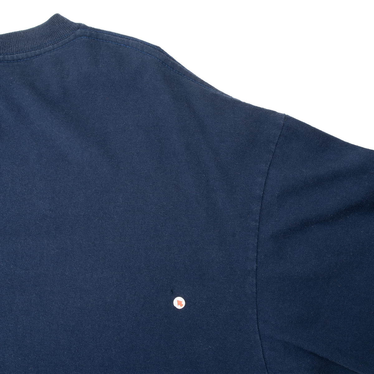 Back shoulder and sleeve detail with small circular red-and-white mark