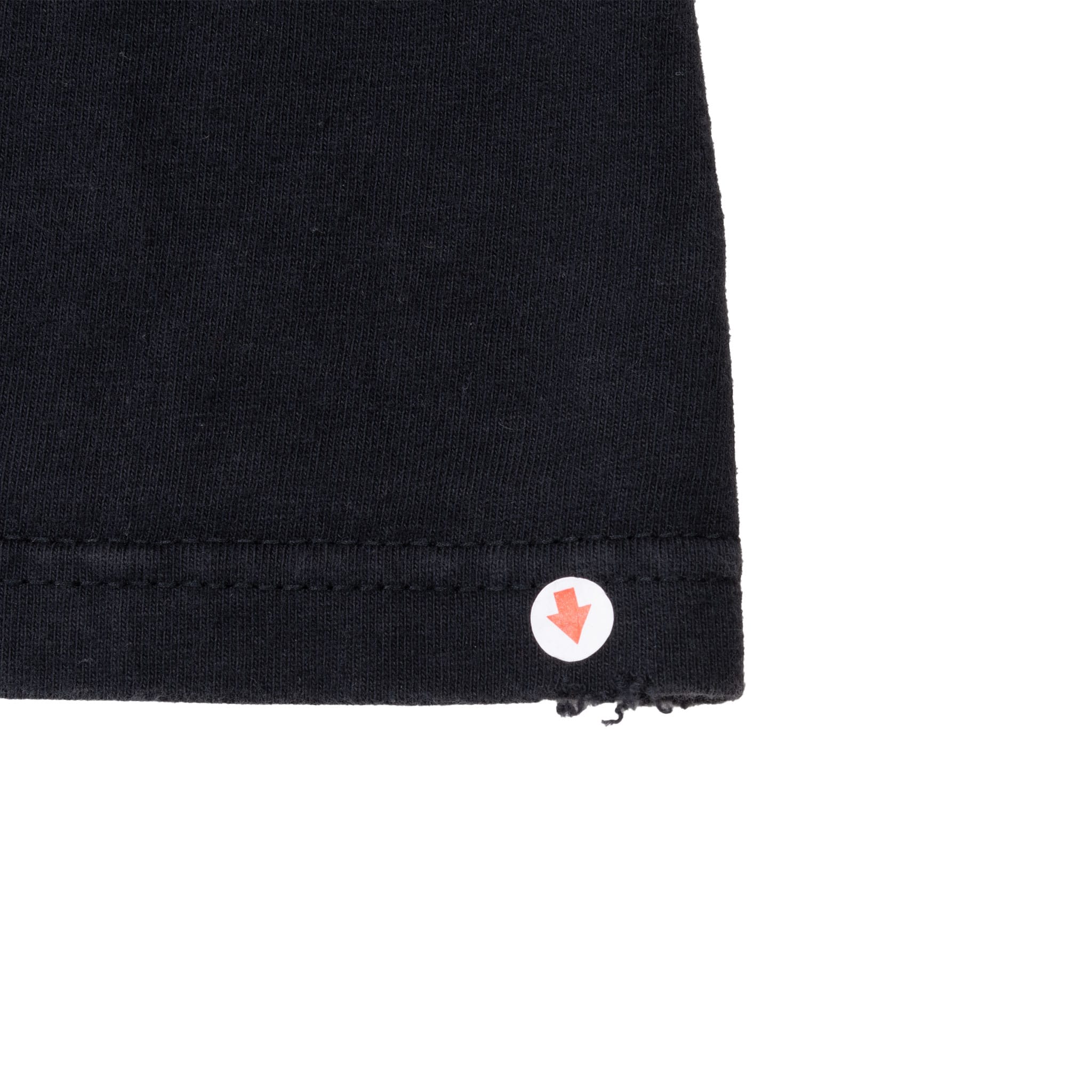 Close-up of black T-shirt hem with arrow marking loose stitching at the edge