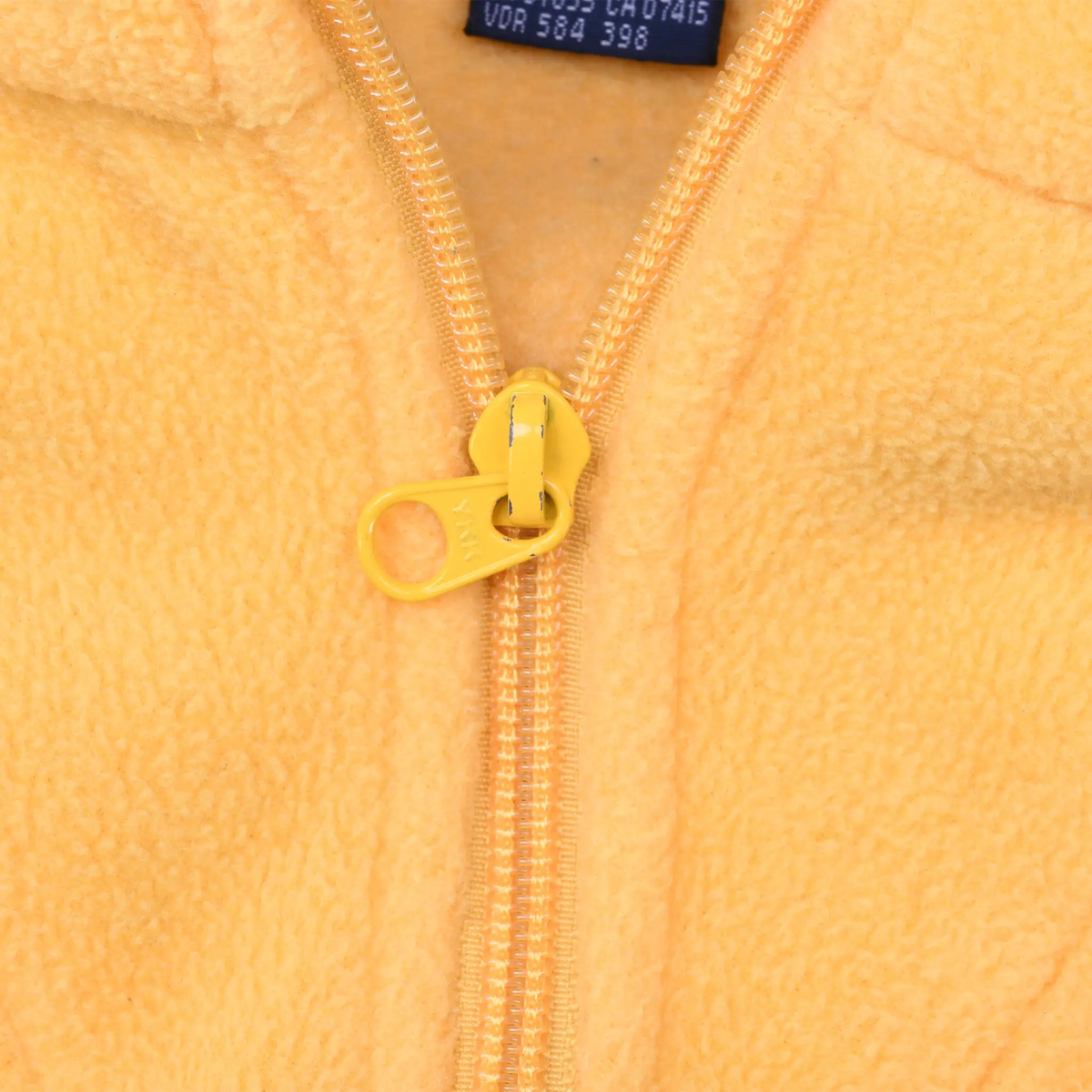 Close-up of yellow ring-pull zipper and textured fleece fabric