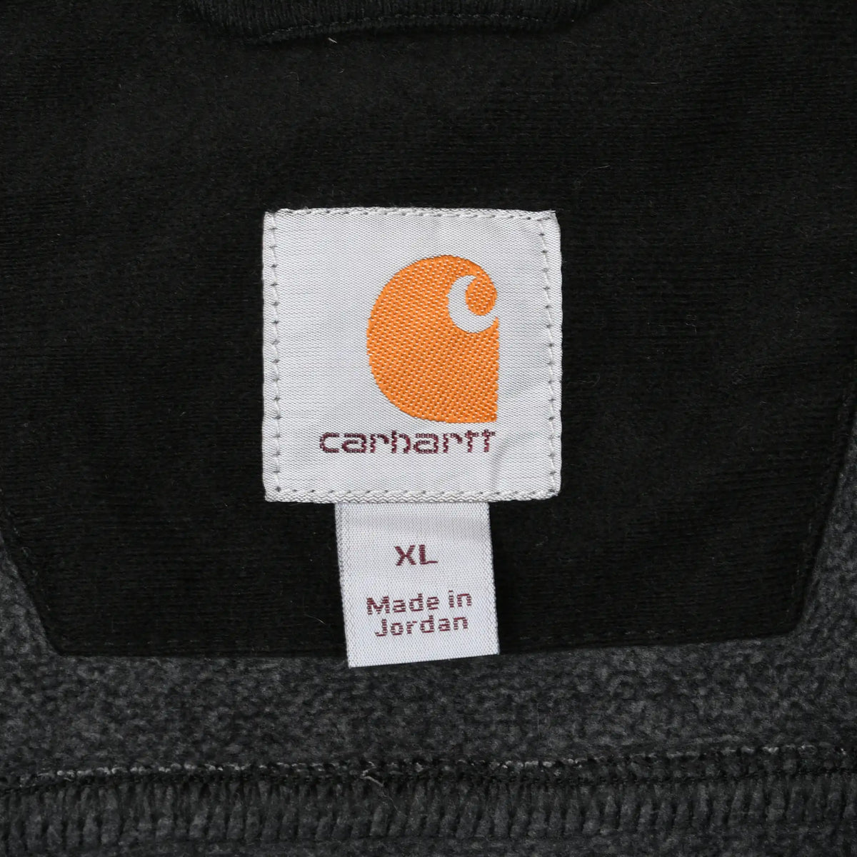 Carhartt neck label with orange logo, XL size tag, and Made in Jordan text