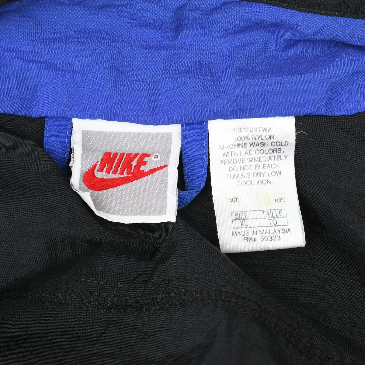 Close-up of Nike neck tag and care label inside the black and blue windbreaker