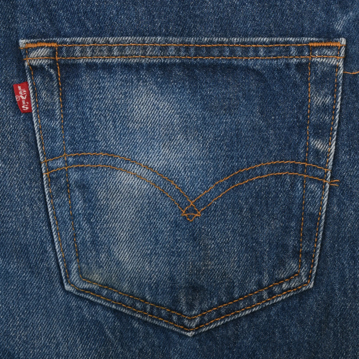 Close-up of Levi's back pocket with arcuate orange stitching and red tab
