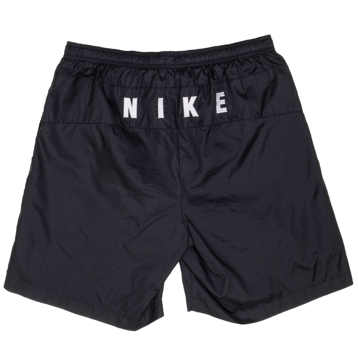 Back of black Nike swim trunks with bold white Nike lettering below waistband